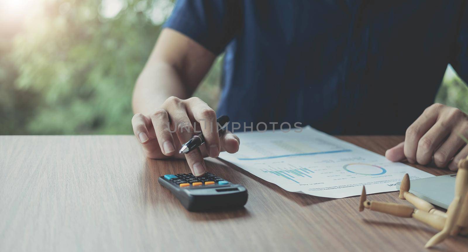 Businessman using calculator for analysis maketing plan, Accountant calculate financial report, computer with graph chart. Business, Finance and Accounting concepts.
