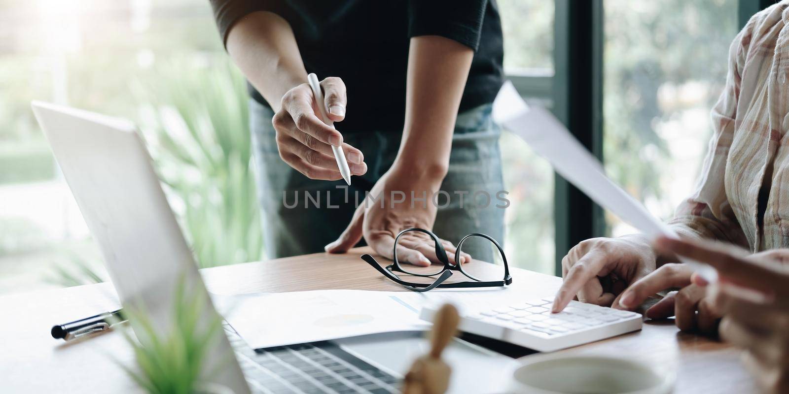 Business meeting time. Photo young account managers crew working with new startup project. Notebook on wood table. Idea presentation, analyze plans. by wichayada