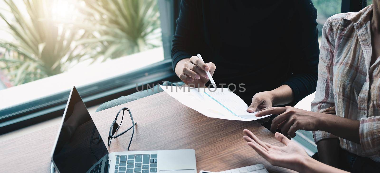 Business meeting time. Photo young account managers crew working with new startup project. Notebook on wood table. Idea presentation, analyze plans. Wide,film effect.