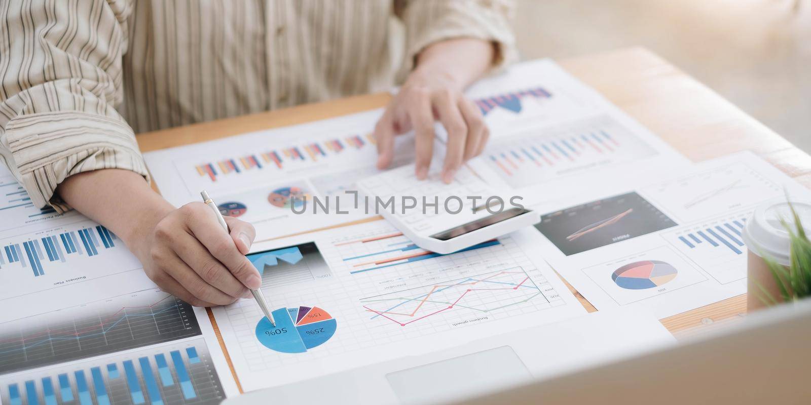 Businessman pen pointing turnover with graph chart report and use calculato for analysis data by wichayada