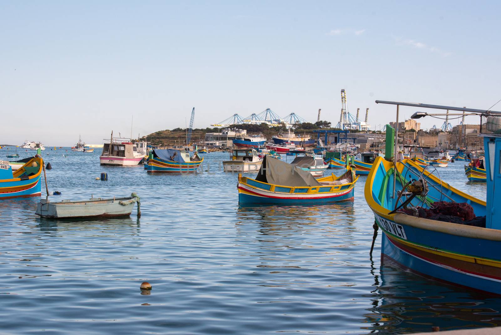 Traditional eyed colorful boats Luzzu in the Harbor of Mediterranean fishing village Marsaxlokk, Malta