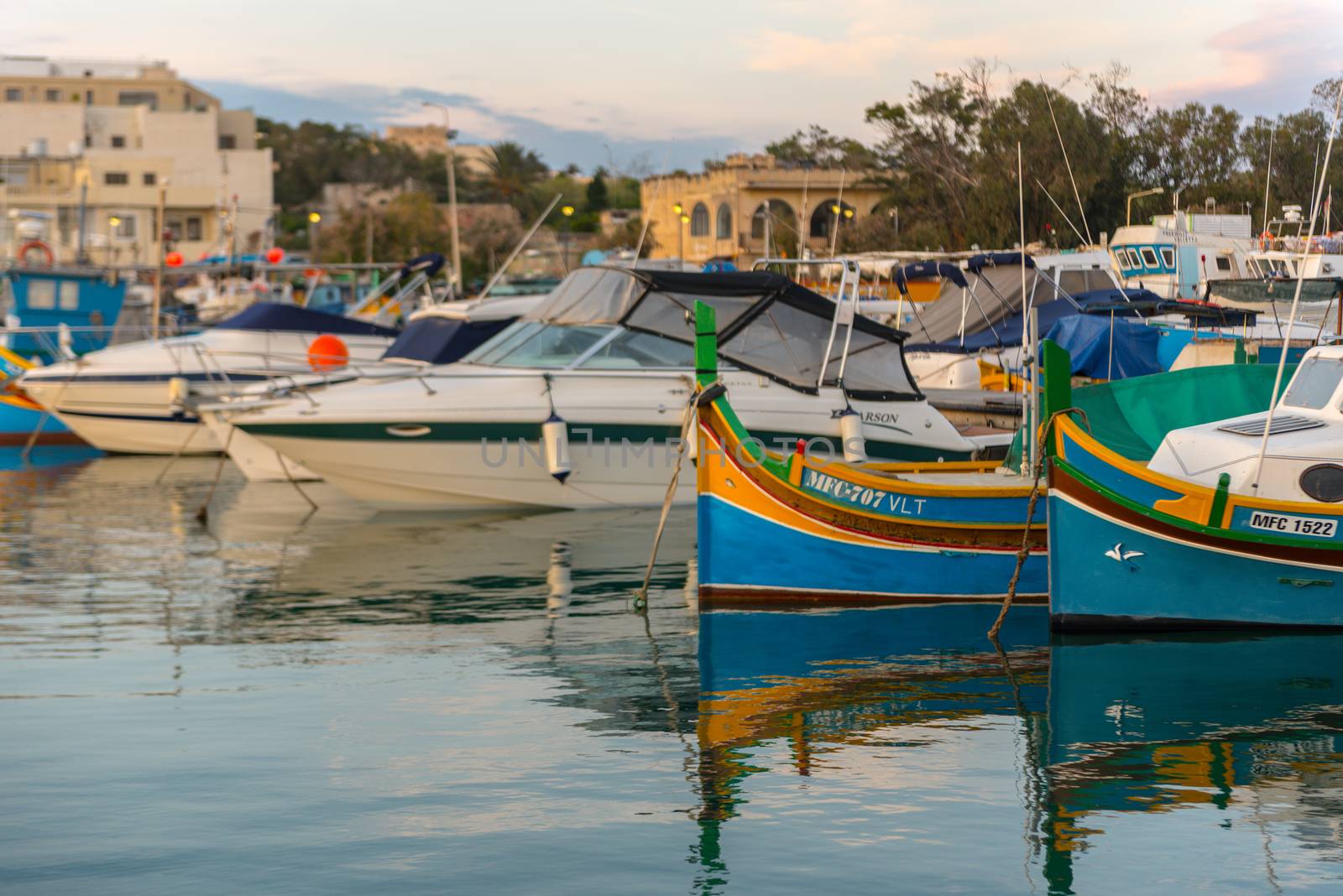 Traditional eyed colorful boats Luzzu in the Harbor of Mediterranean fishing village Marsaxlokk, Malta