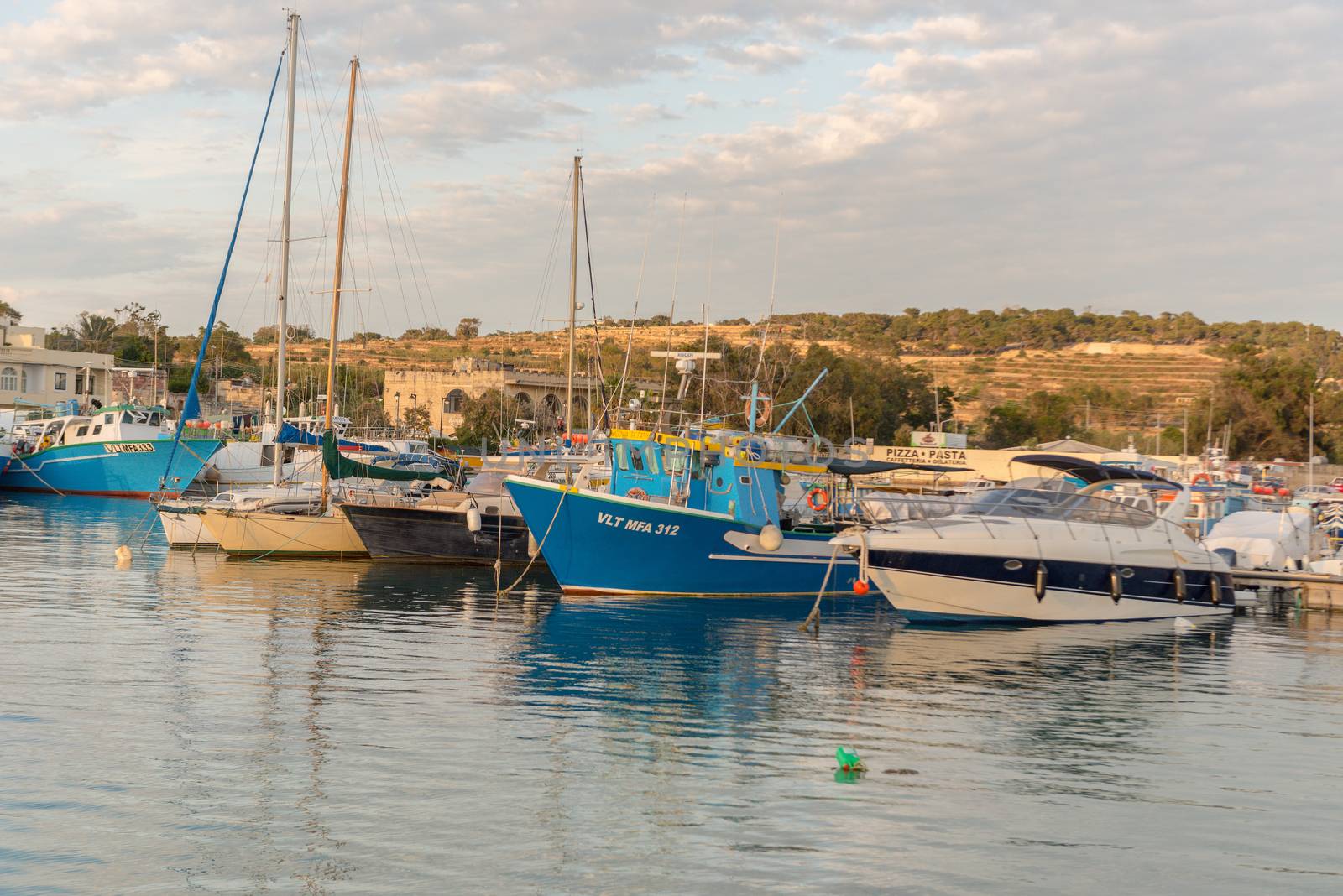Traditional eyed colorful boats Luzzu in the Harbor of Mediterranean fishing village Marsaxlokk, Malta