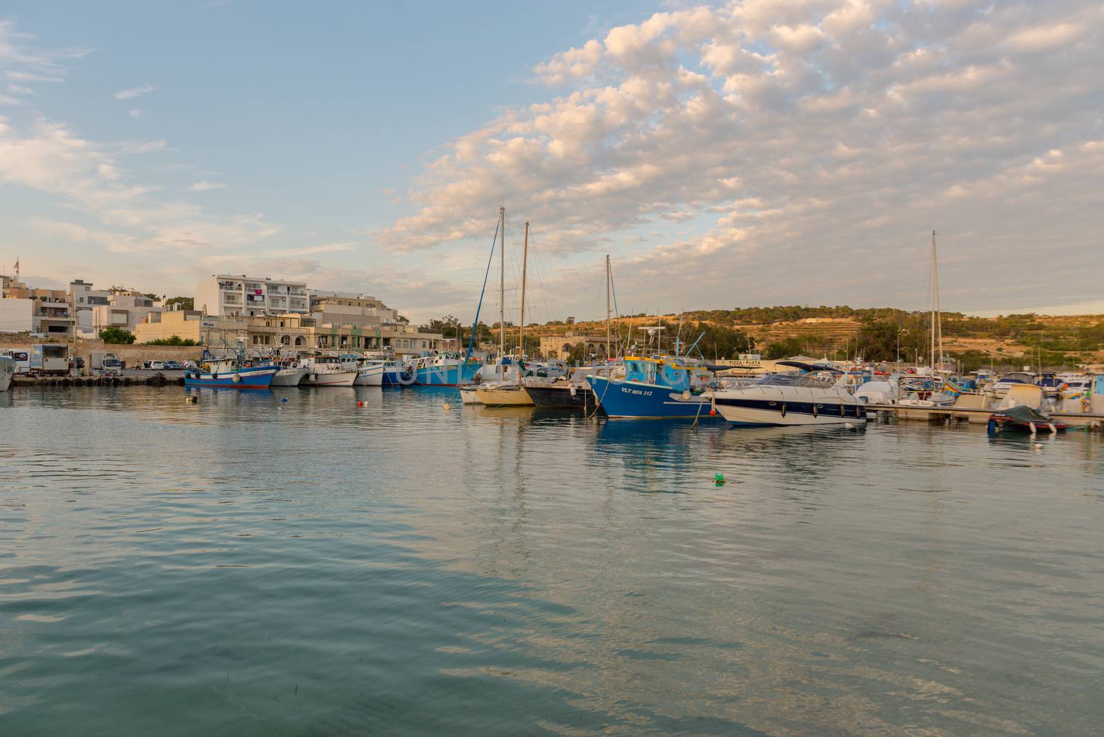 Traditional eyed colorful boats Luzzu in the Harbor of Mediterranean fishing village Marsaxlokk, Malta