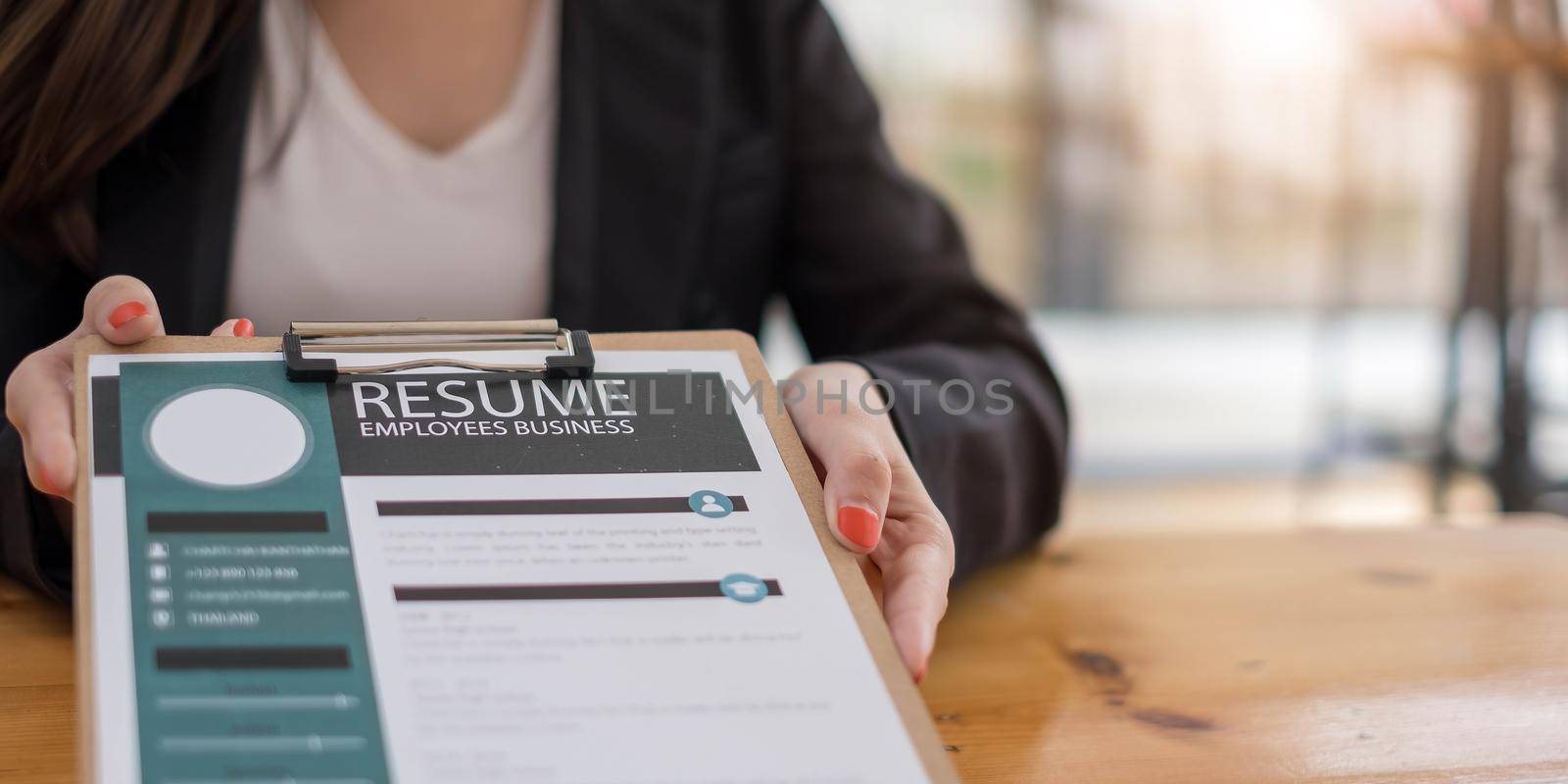 Businesswoman submits resume employer to review job application information on the desk, presents the ability for the company to agree with the position of the job. by wichayada