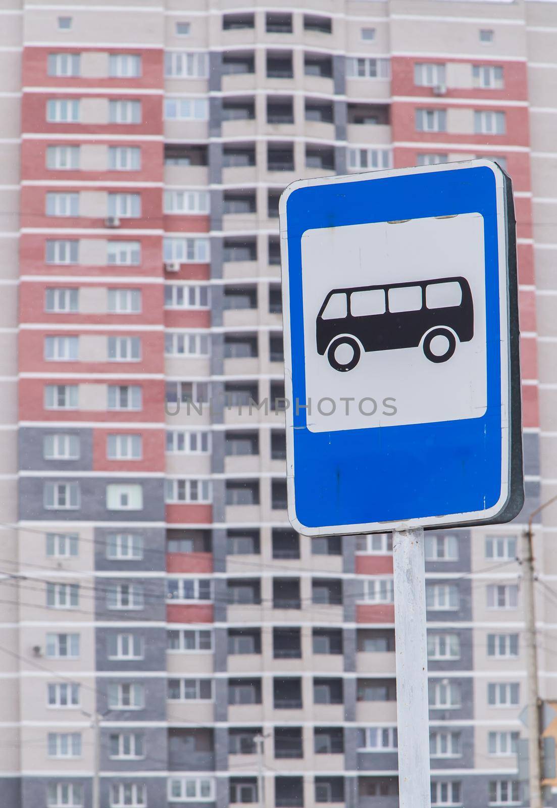 Close-up road sign bus stop on the background of a high-rise building. City life and road traffic concept. Elements of a modern metropolis.