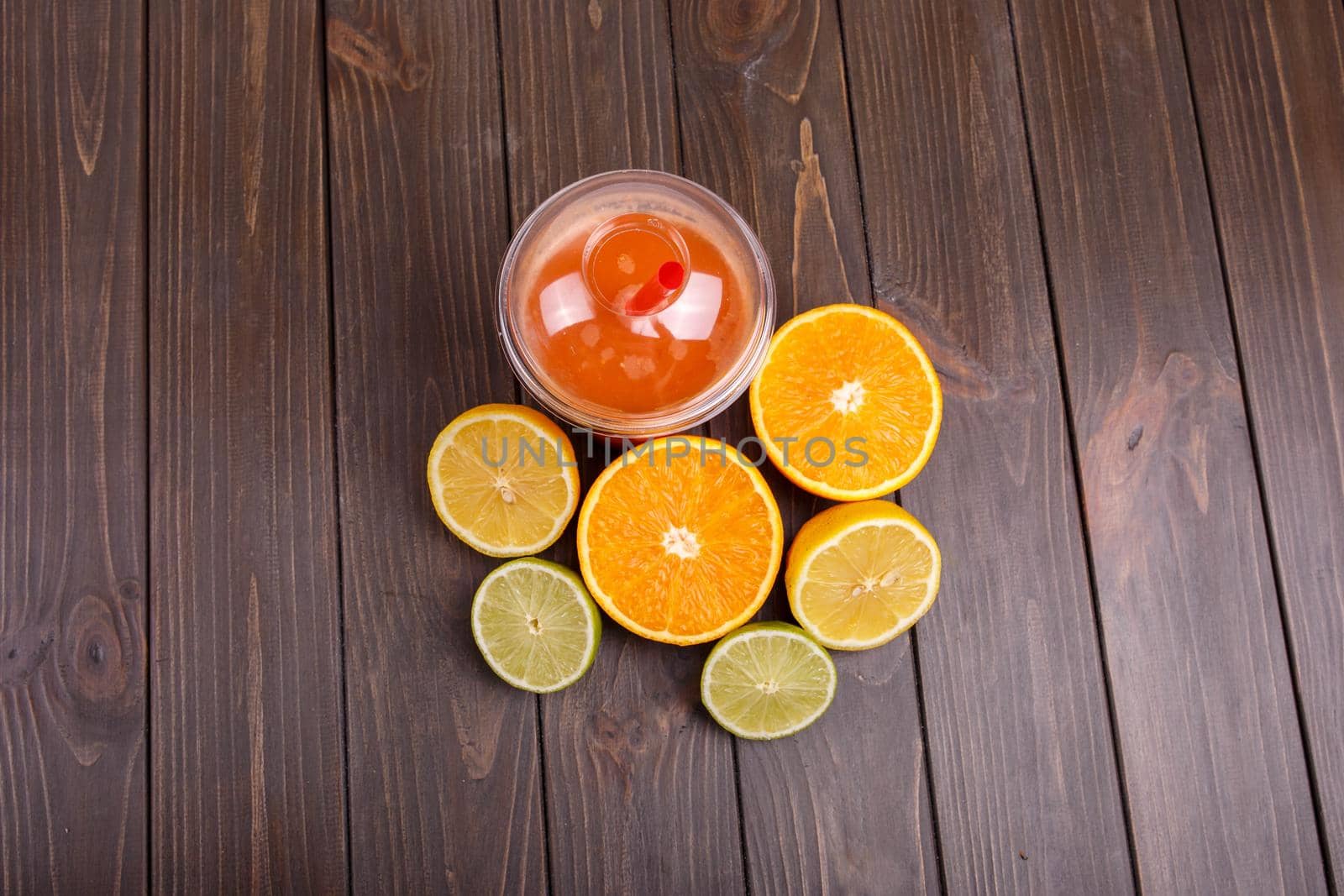 orange detox coctail with half orange,lemon and lime lies on table