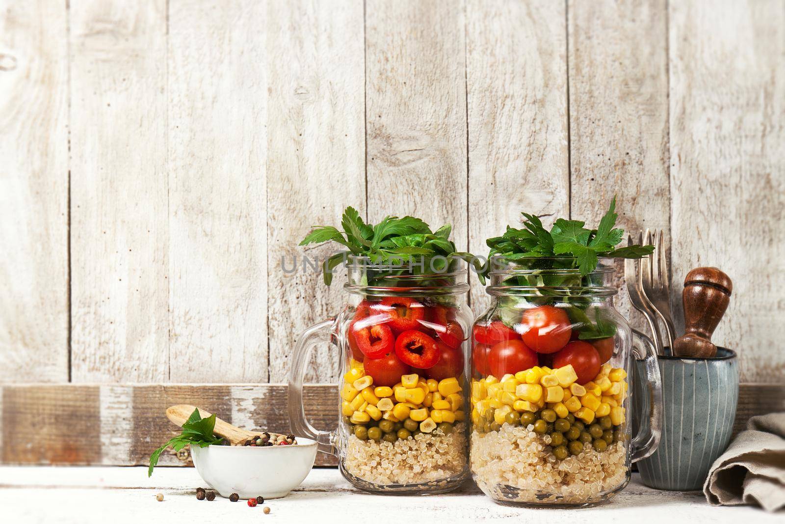 Homemade healthy layer salad in mason jars on a wooden background. Healthy life, food, detox concept