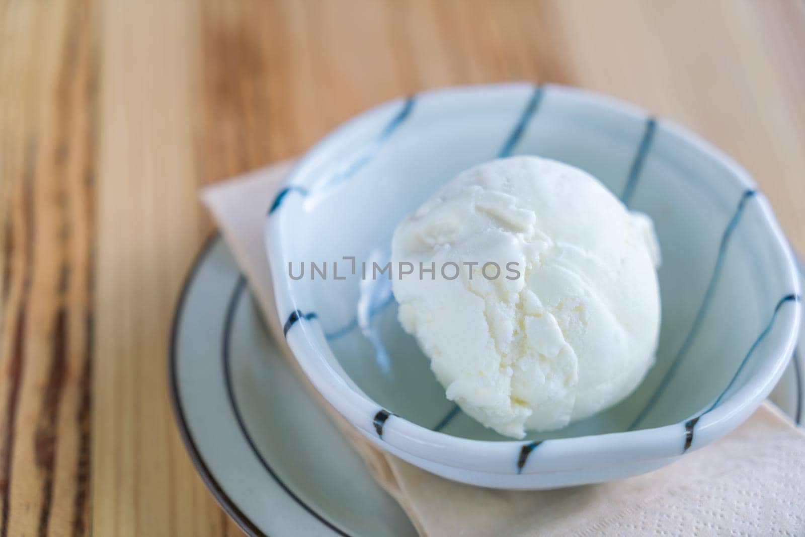 Milk ice cream in bowl on wood table