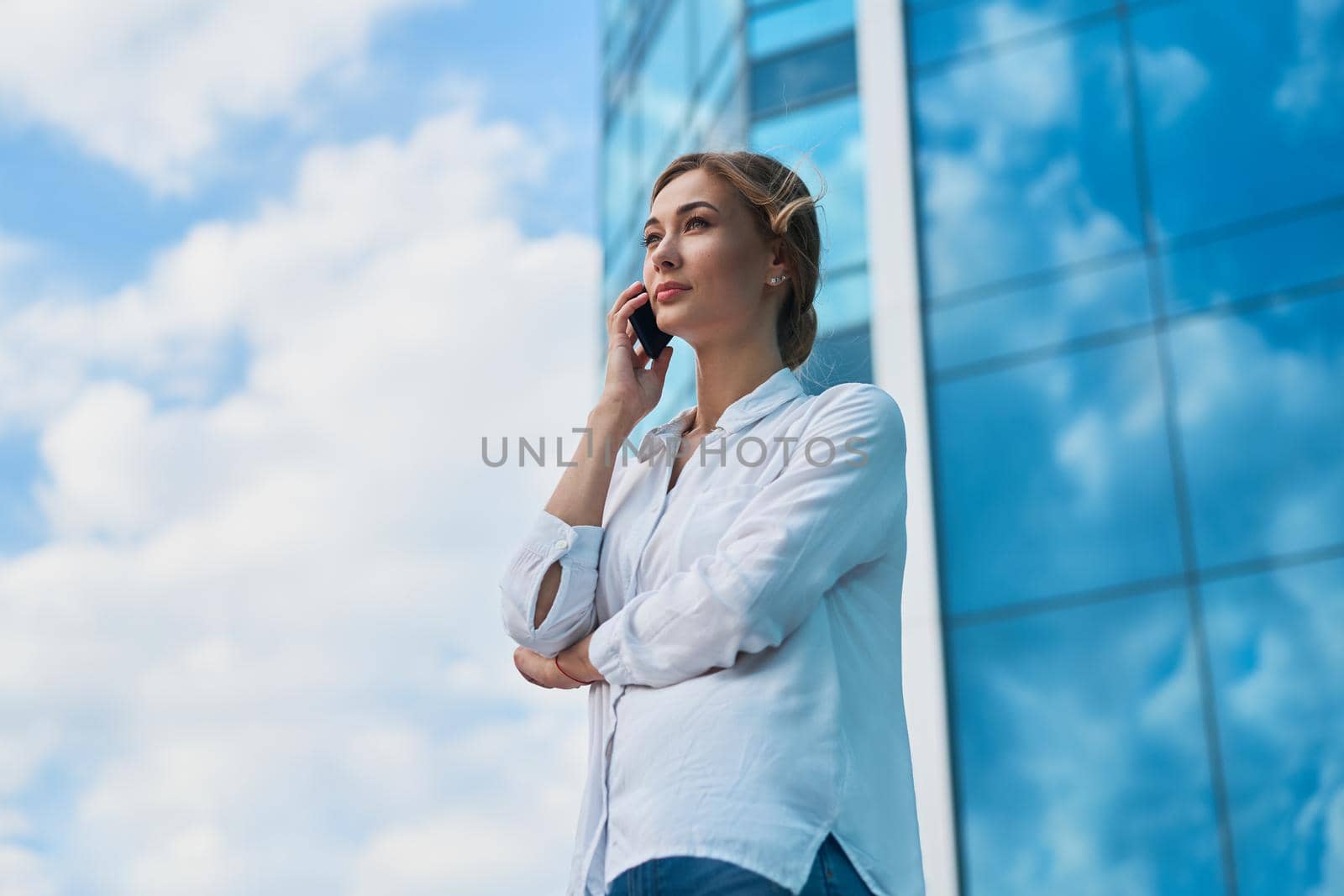 Businesswoman successful woman business person standing outdoor corporate building exterior. Pensive caucasian confidence professional business woman middle age by andreonegin