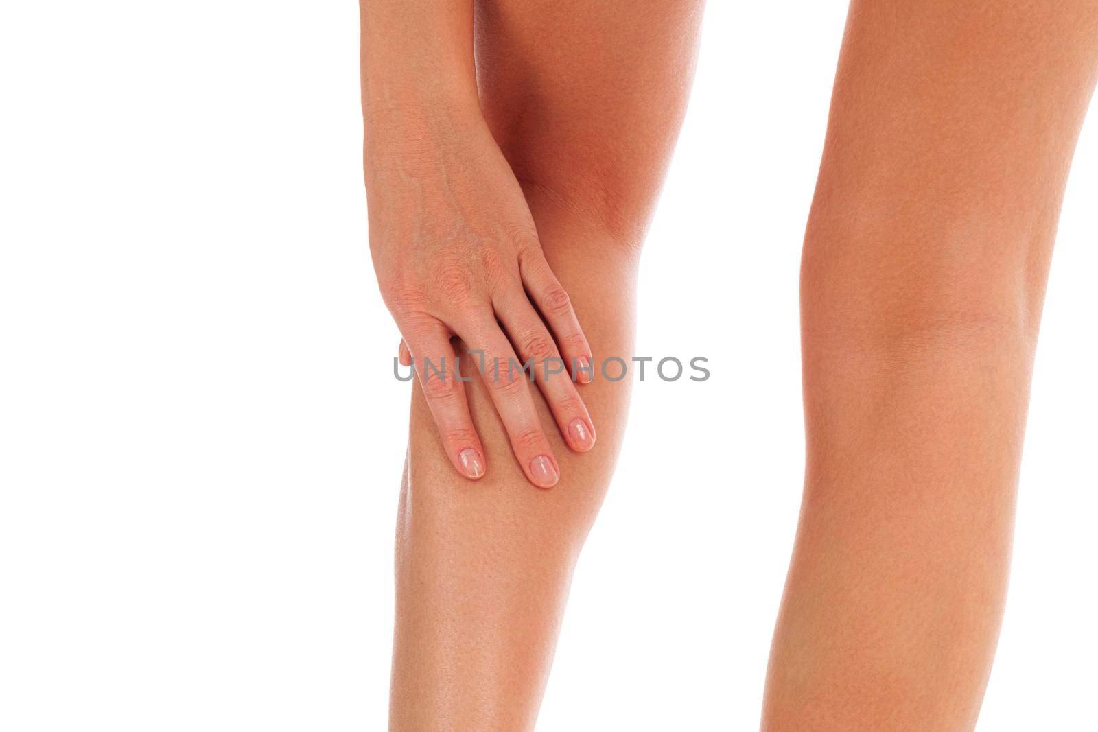 Woman touches her painful shin, isolated on white background by Nobilior
