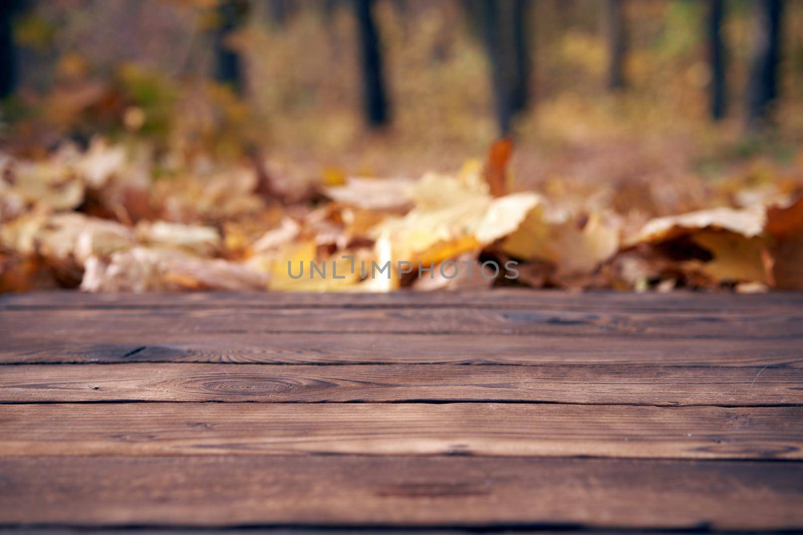 Empty wooden table autumn maple leaves nature bokeh background with a country outdoor theme,Template mock up for display of product Copy space
