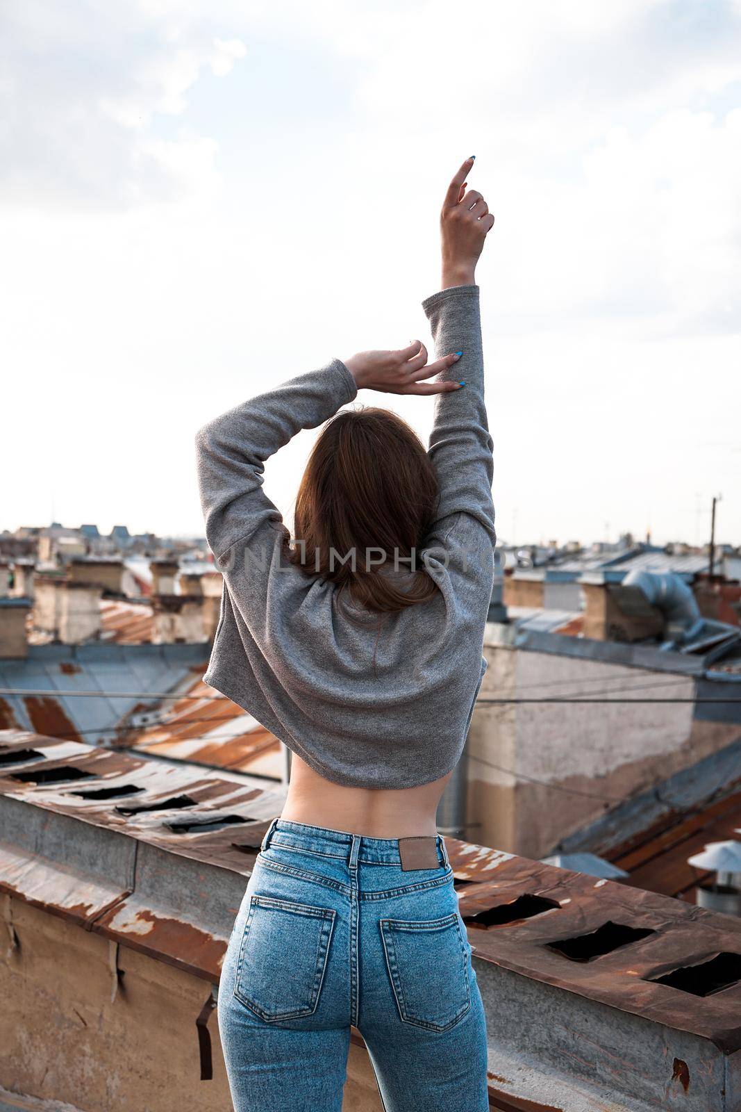 Woman is happy on the roof of Saint Petersburg, Russia. Cityscape view over the rooftops of St. Petersburg.
