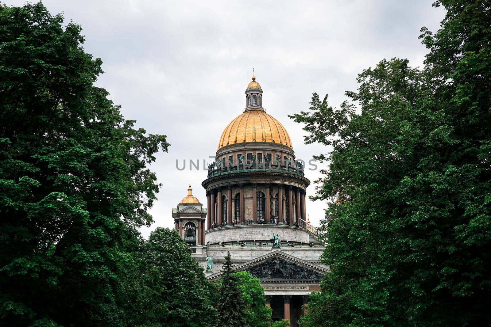 Saint Isaac cathedral in St Petersburg, Russia. The dome of the cathedral is visible through the green crown of trees