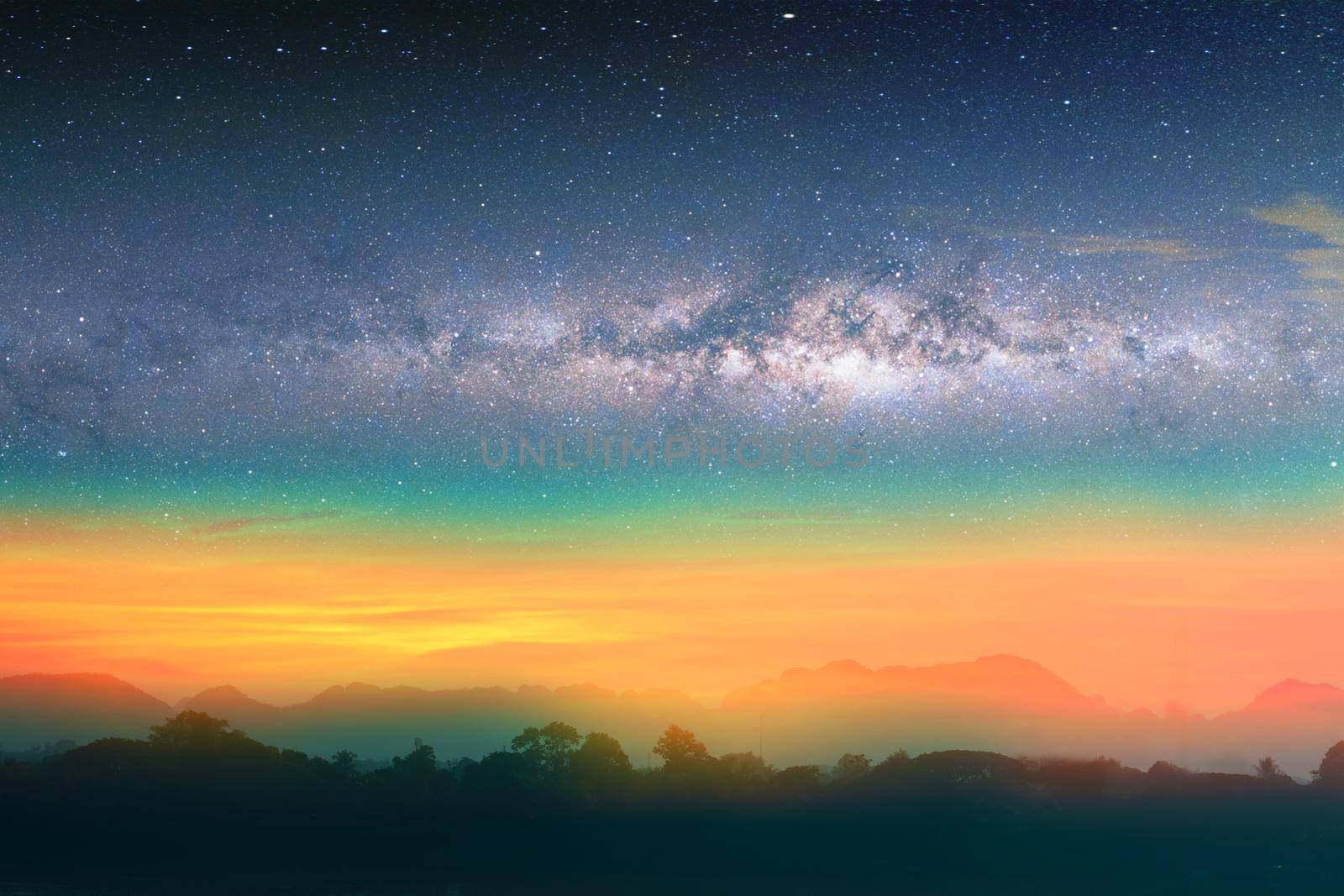 Milky way night landscape sunset rainbow light over silhouette mountain, space and stars on sky background