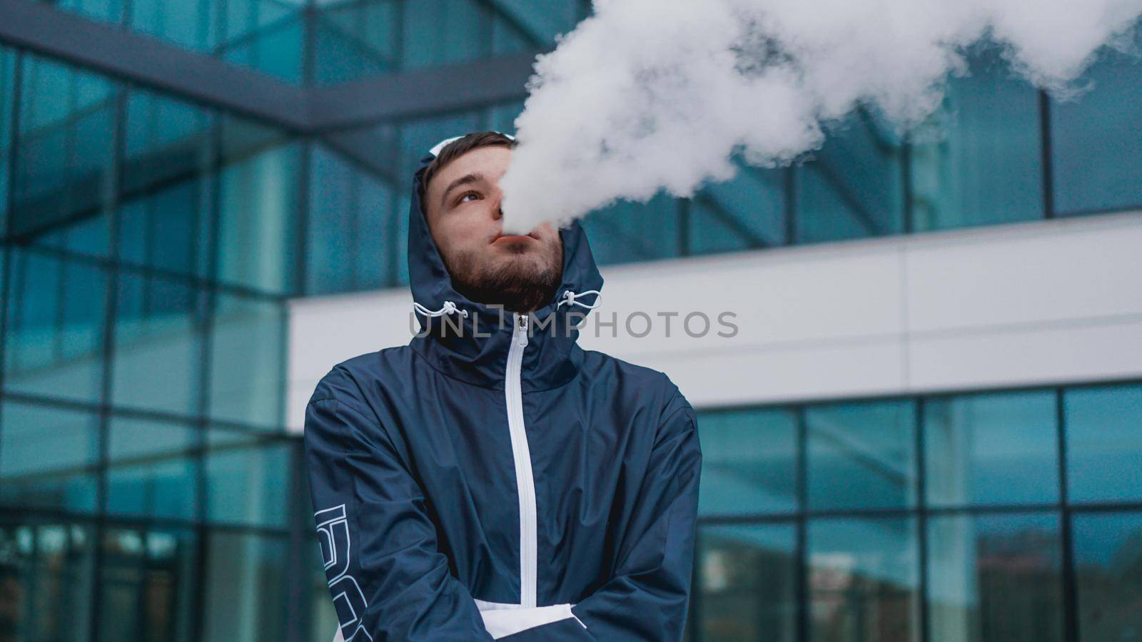 Man smoking electronic cigarette vapor. Smoking Electronic Cigarette by natali_brill