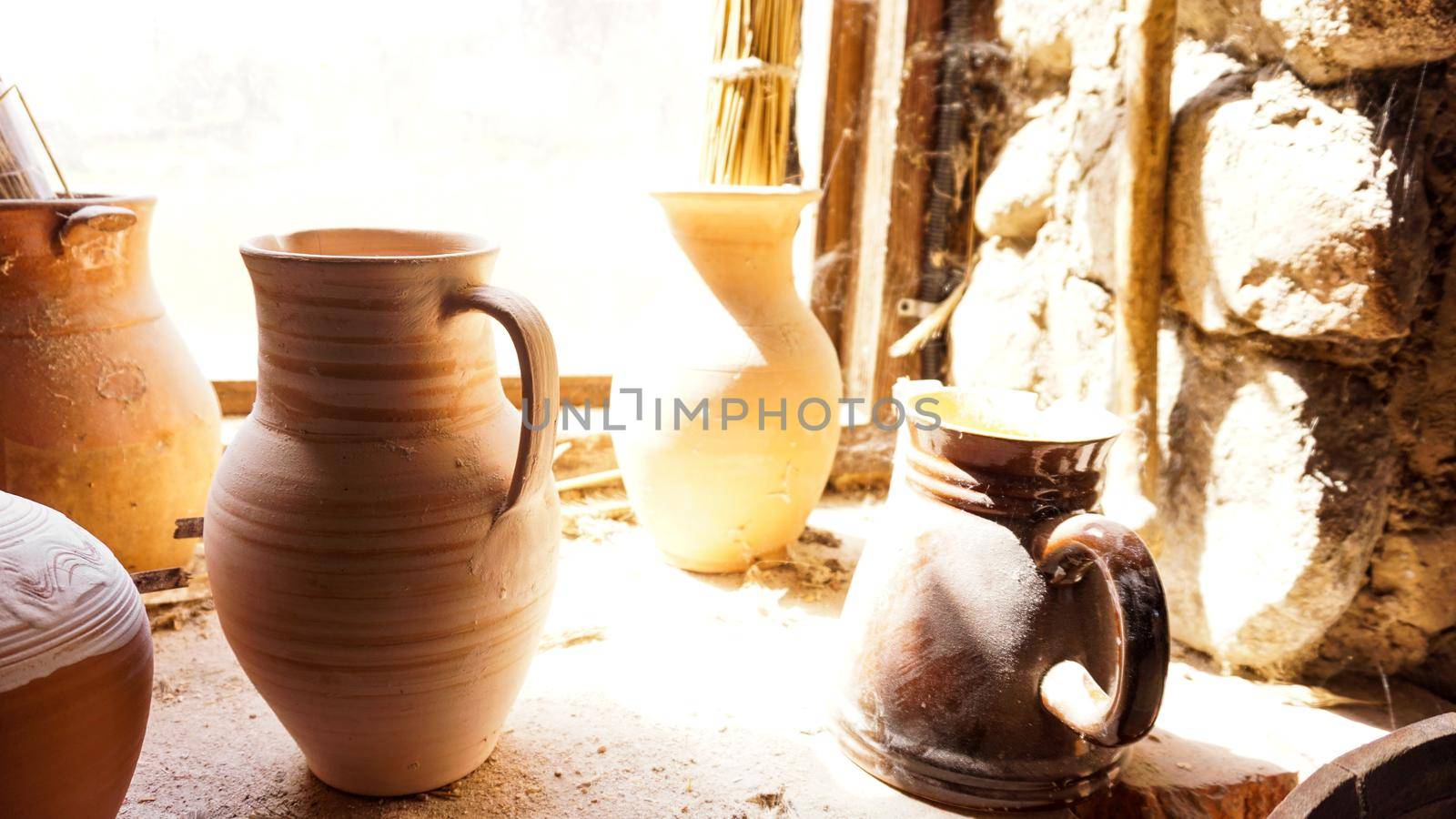 Old clay pot in an old room. Old dusty shelves in a pottery workshop. by natali_brill
