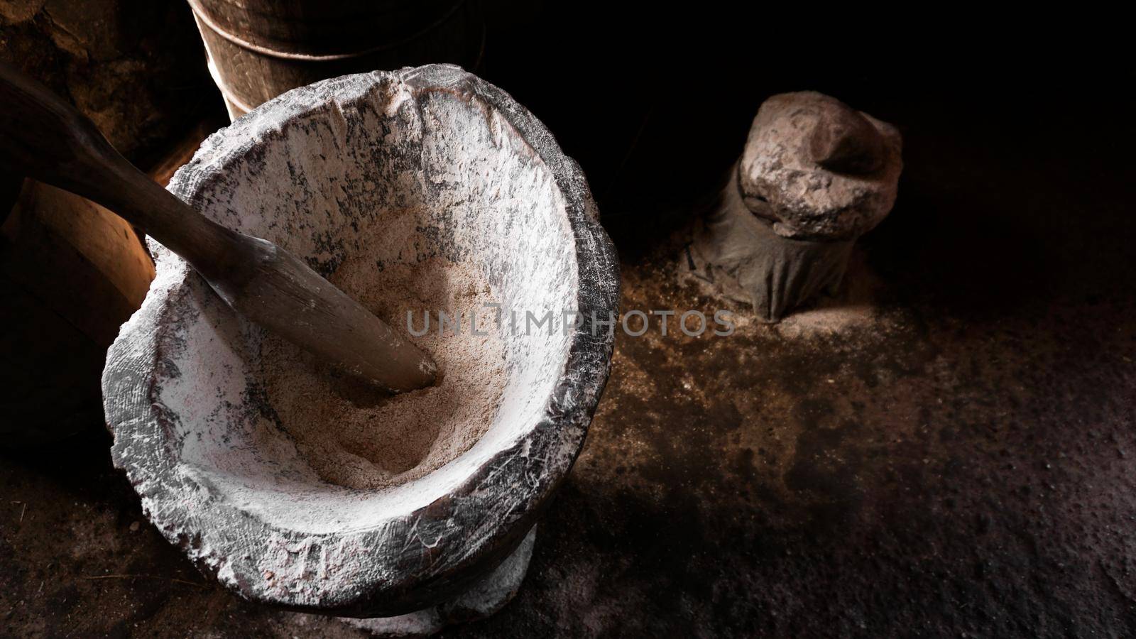 Ancient flour mortar. Wooden vessel for manual hand grinding. Authentic craft workshop. This method has been in use for many thousand years.
