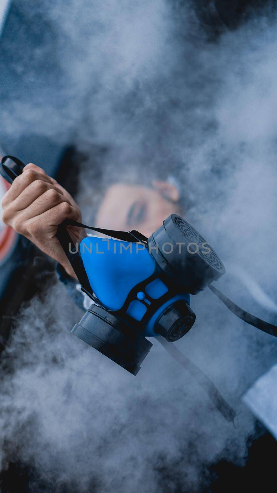 Protection respirator half mask for toxic gas.The man prepare to wear protection air pollution. Man holds a respirator, arm extended forward