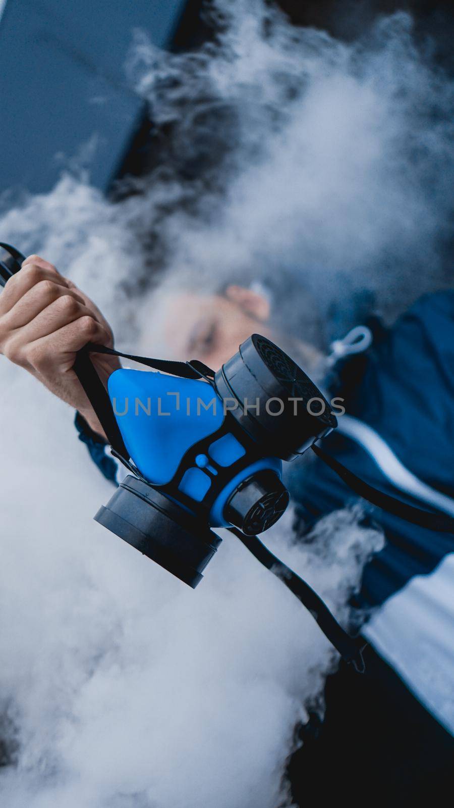 Protection respirator half mask for toxic gas.The man prepare to wear protection air pollution. Man holds a respirator, arm extended forward