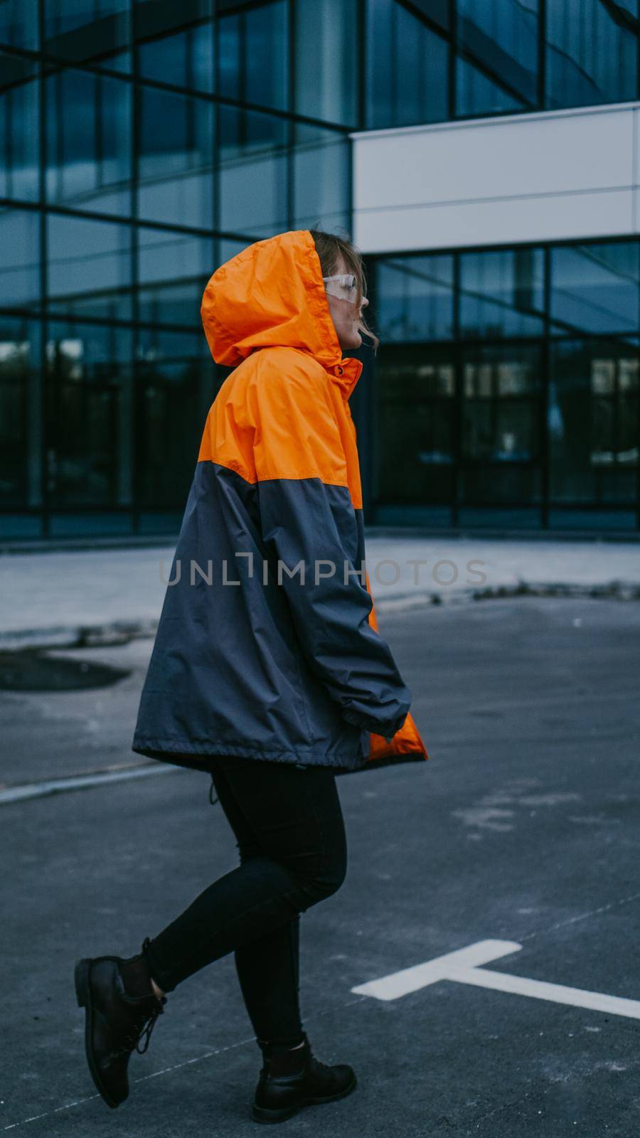 Girl in orange protective overalls and glasses. Air pollution and hazard concept