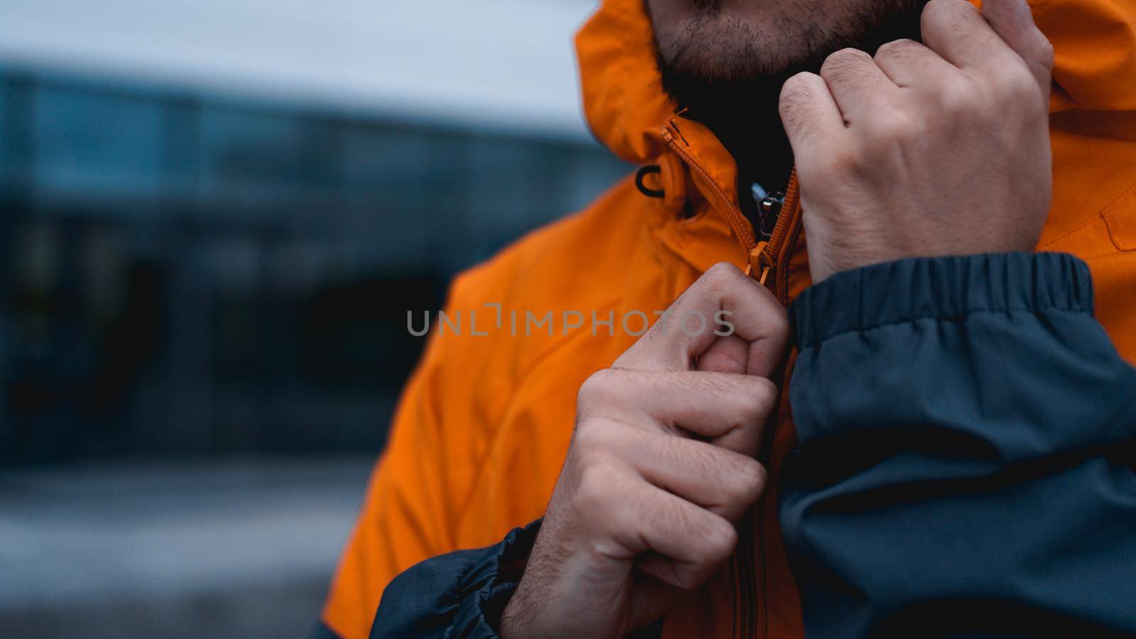 A man fastens his work uniform. Orange worker uniform - hands close up