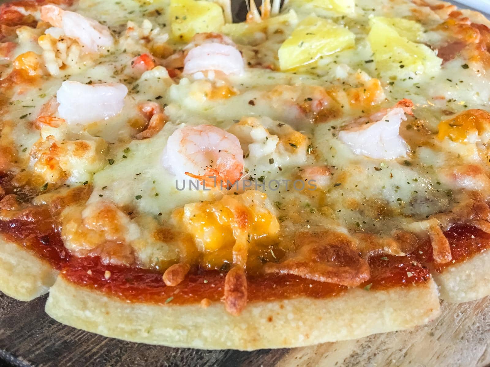Pizza seafood with shrimp, squid and shell on wood tray in restaurant.