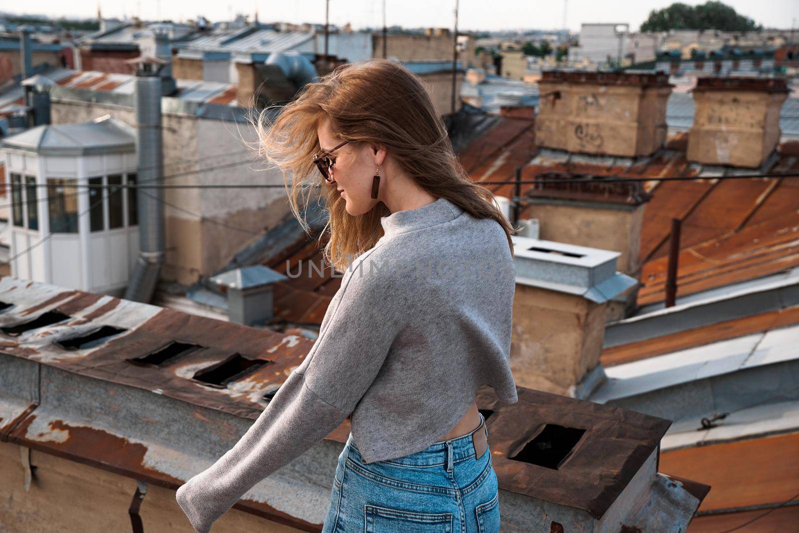 Woman is happy on the roof of Saint Petersburg, Russia. Cityscape view over the rooftops of St. Petersburg.