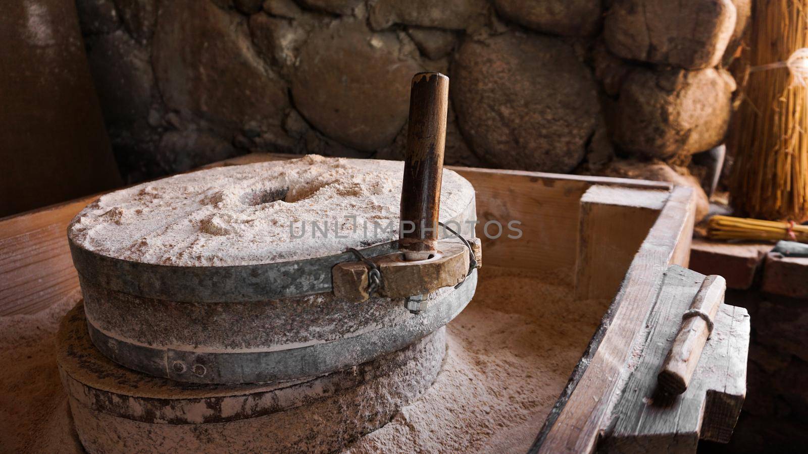 An ancient hand mill made of stones and wood. Flour grinding device by natali_brill