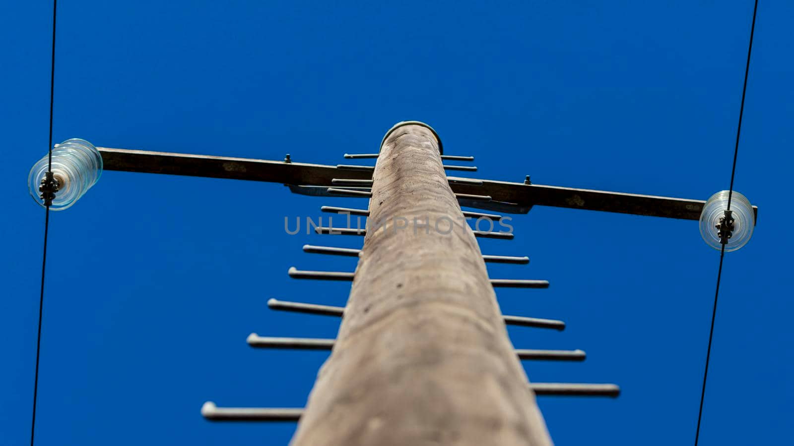 Photograph looking up a telephone pole into blue sky by WittkePhotos