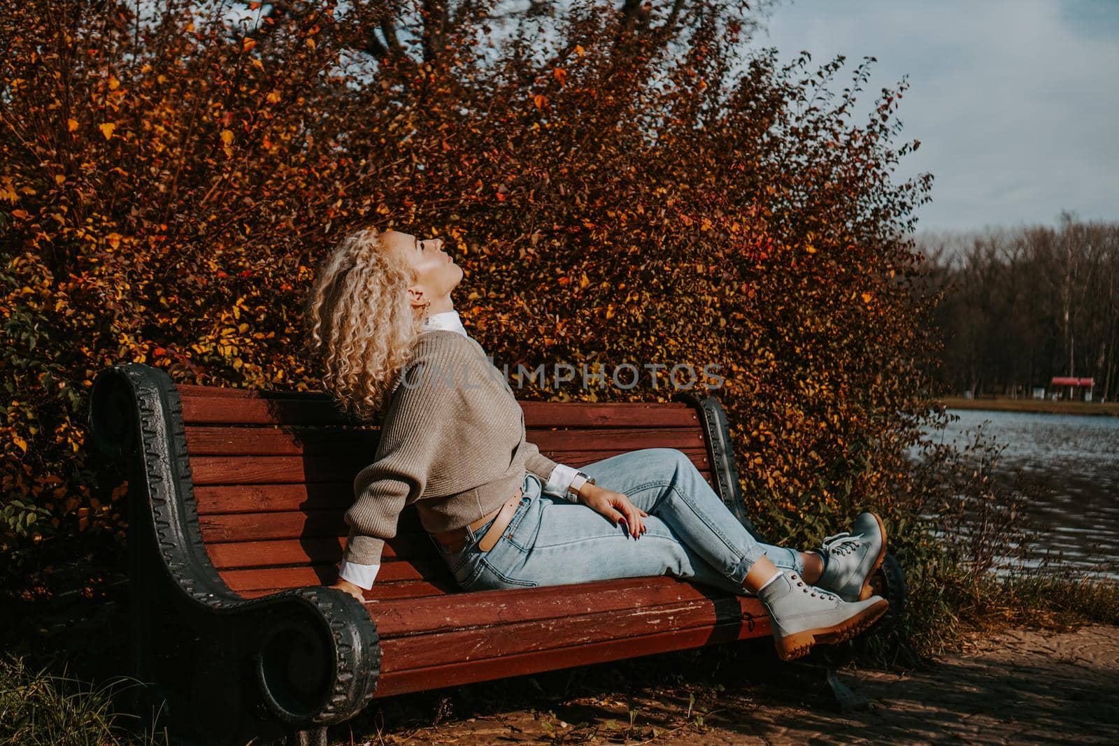 Middle-aged Woman sitting on the bench at autumn city park