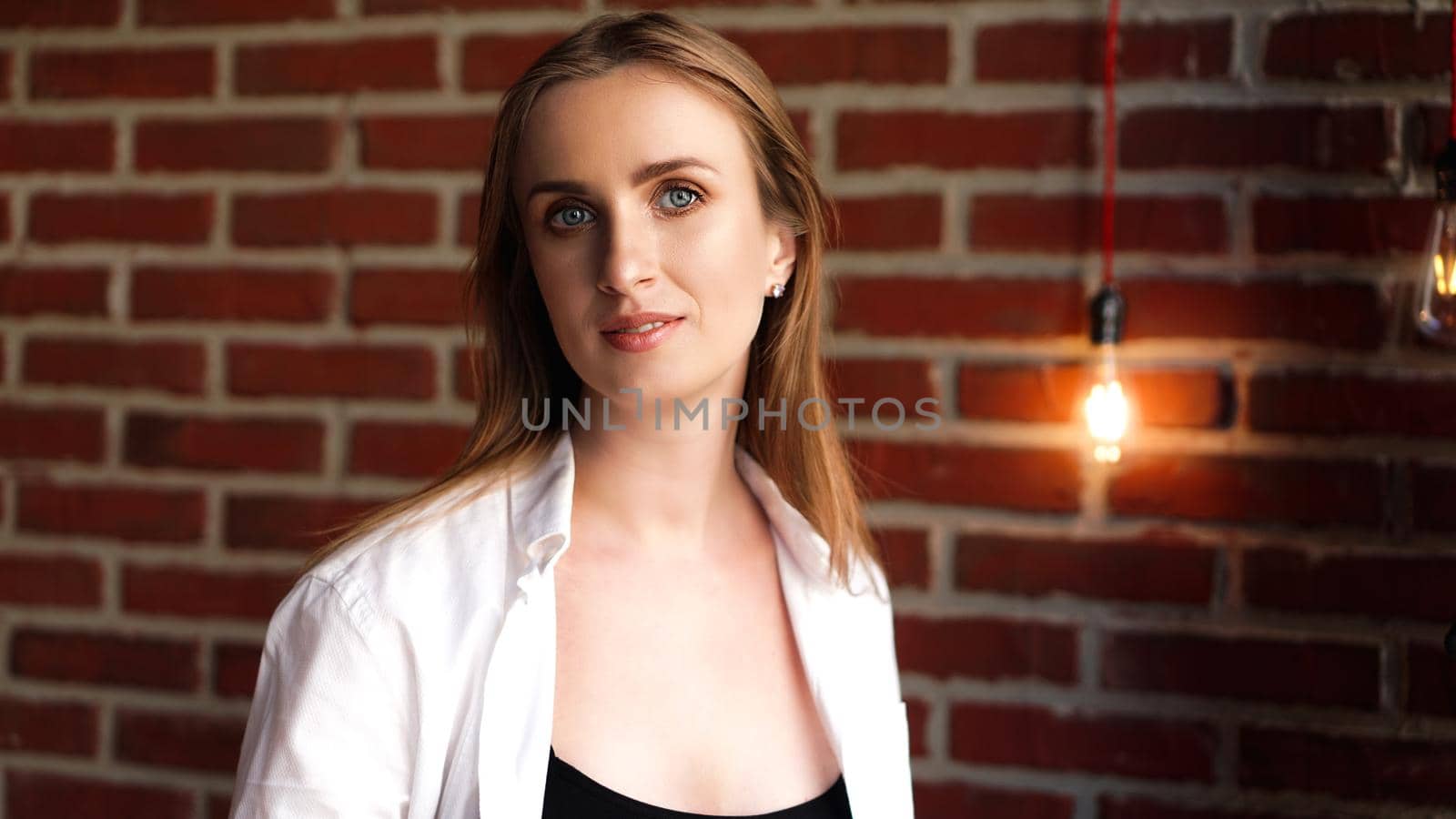 Close up Happy Young Woman Wearing Casual white shirt In Front red Brick Wall - Loft interior