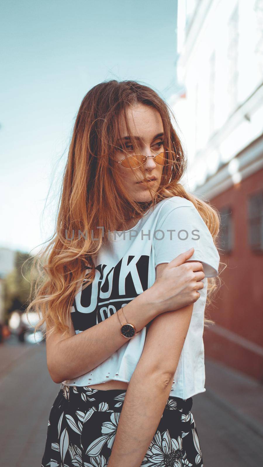 Fashion portrait stylish pretty woman in sunglasses posing in the city, street fashion. You look cool on white t-shirt