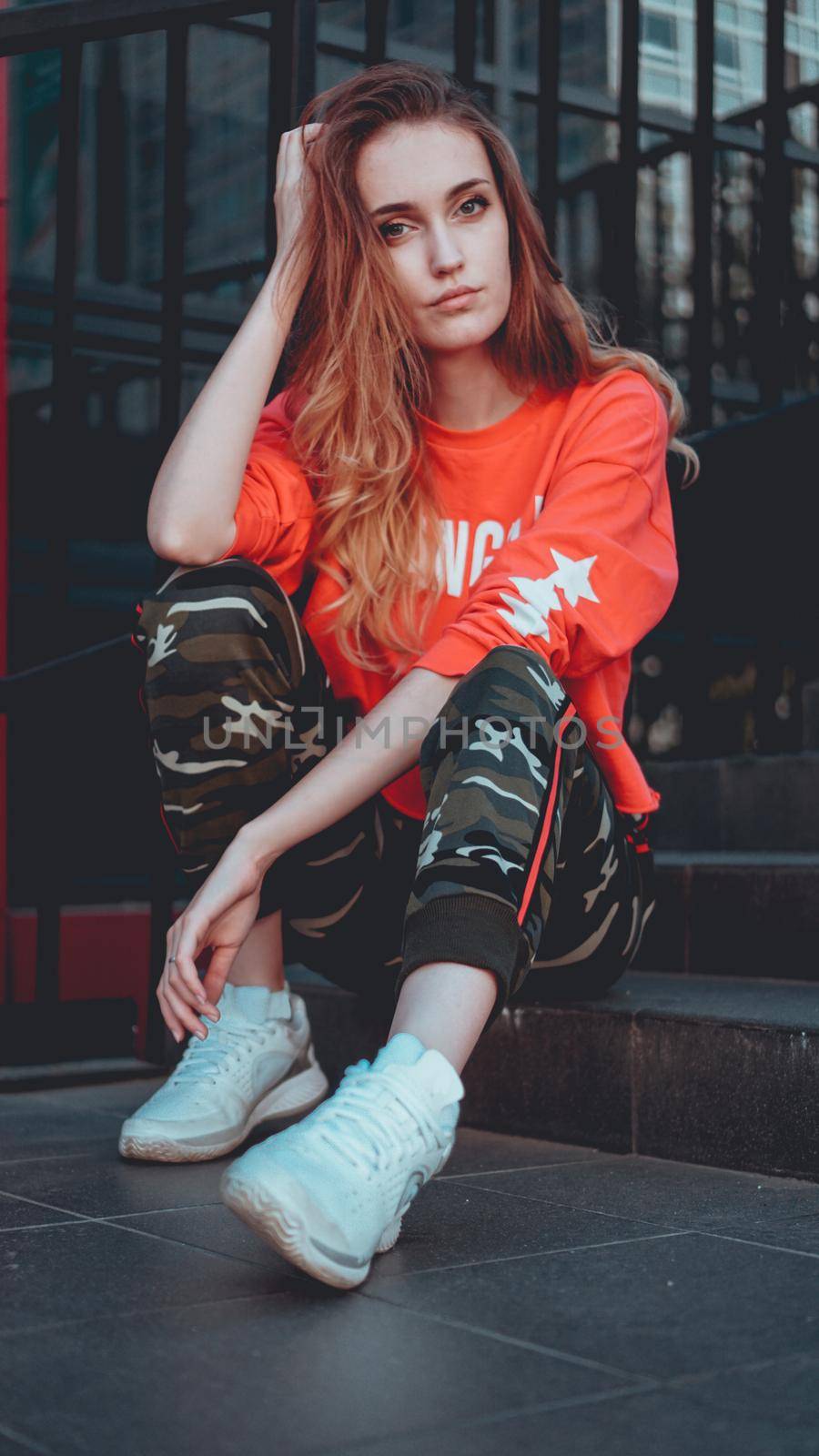 Fashion model wearing red hoodie with inscription los angeles posing at parking by natali_brill