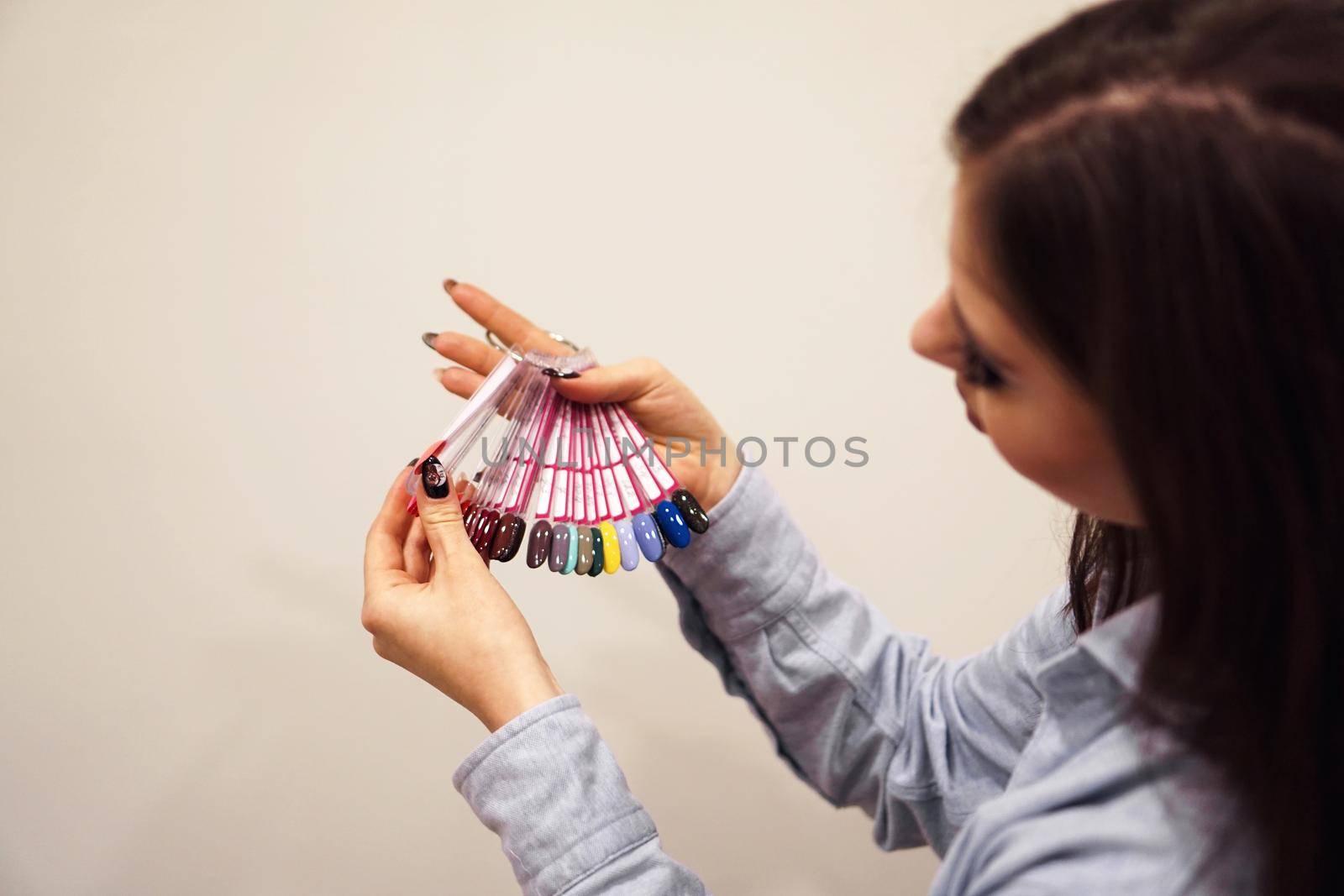 The girl chooses the color of Polish for manicure. Testers nail Polish