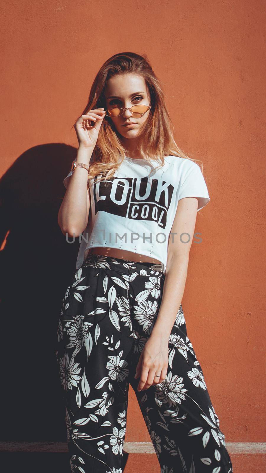 Fashion portrait stylish pretty woman in sunglasses posing in the city, street fashion. You look cool on white t-shirt