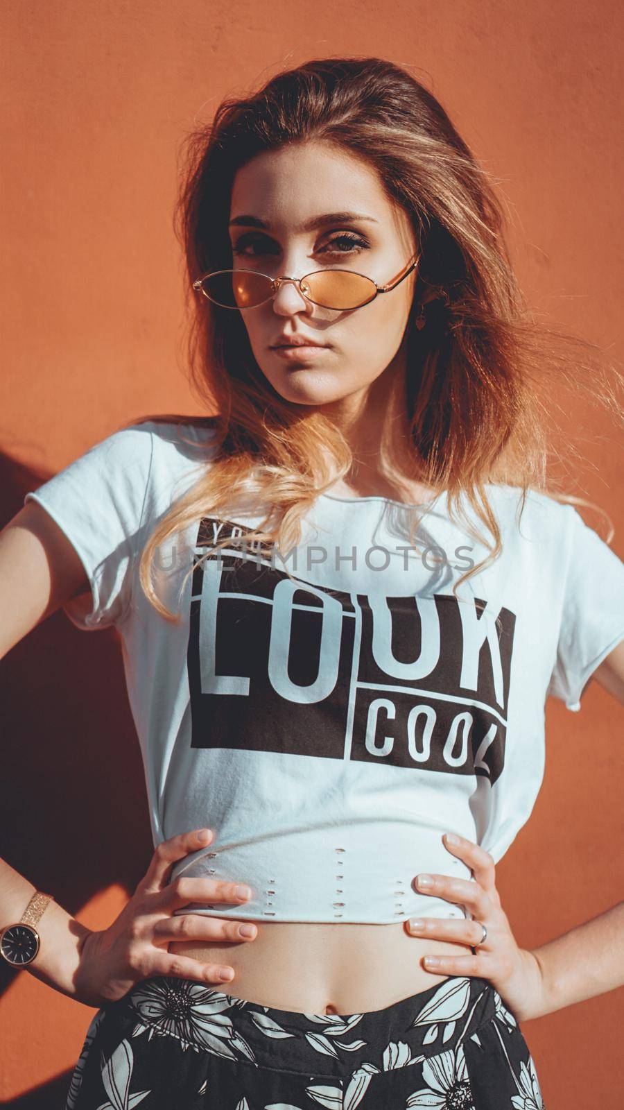 Fashion portrait stylish pretty woman in sunglasses posing in the city, street fashion. You look cool on white t-shirt