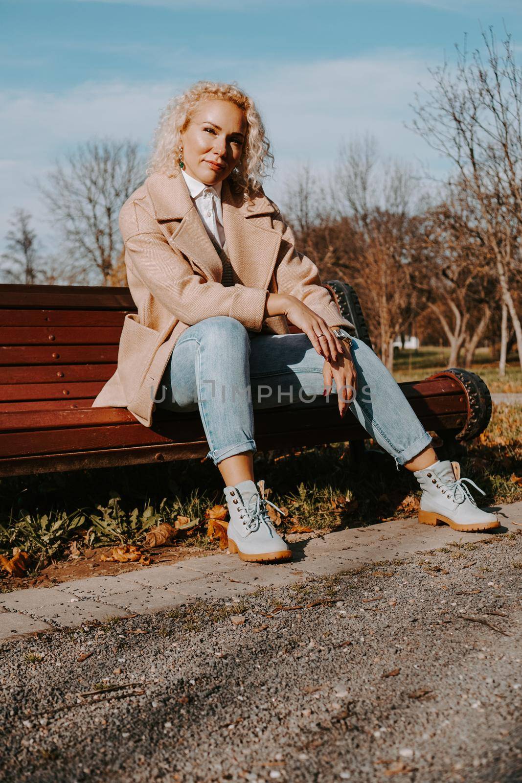 Middle-aged Woman sitting on the bench at autumn city park