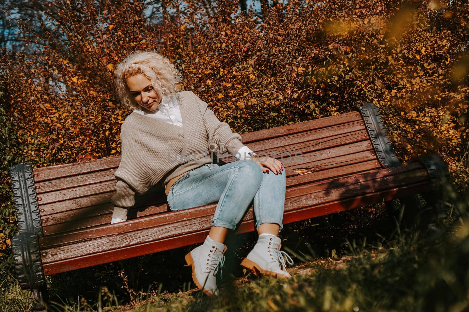 Middle-aged Woman sitting on the bench at autumn city park