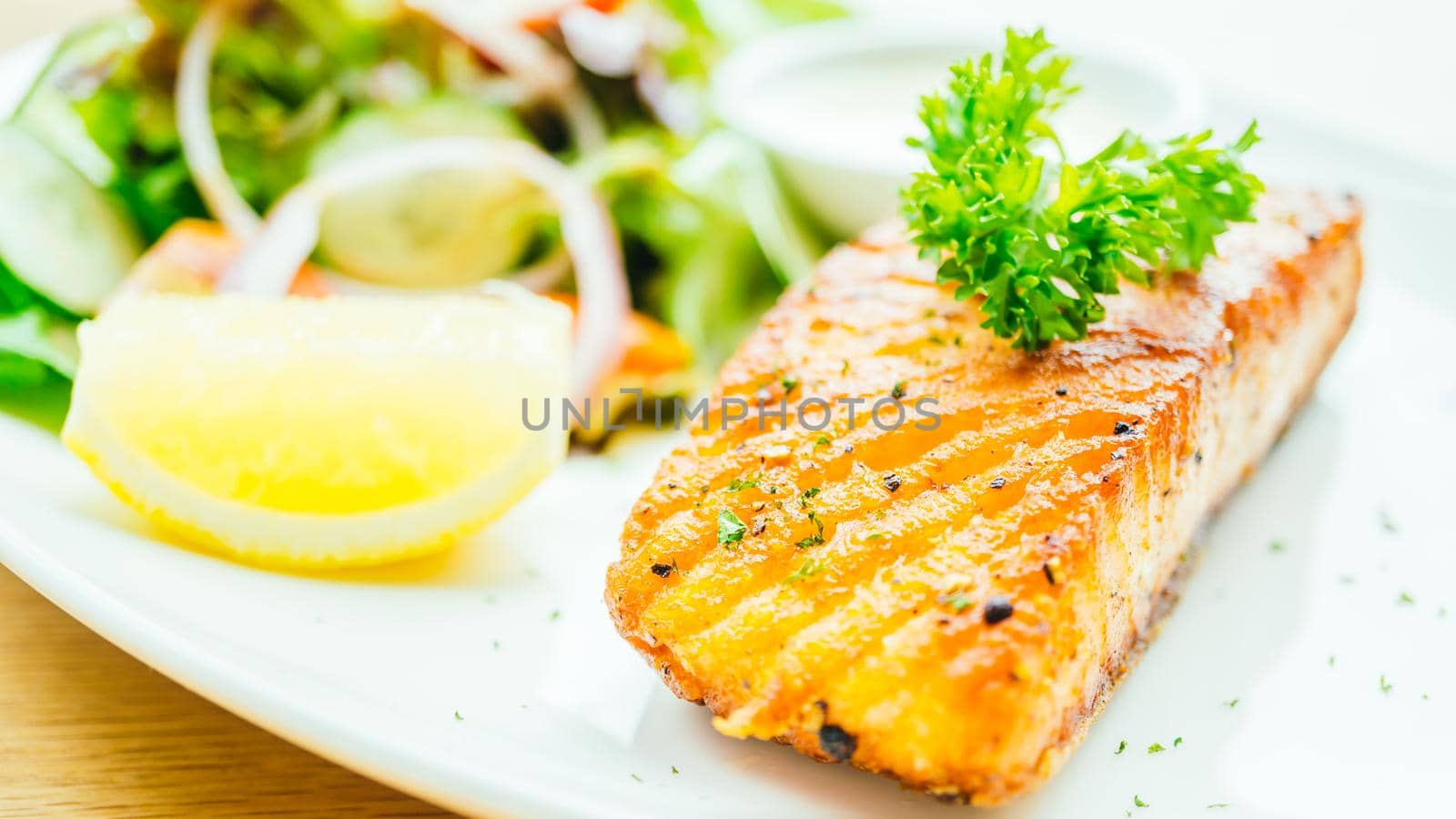 Salmon meat fillet steak with vegetable salad in white plate