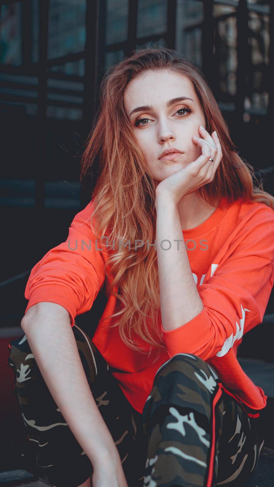 Fashion model wearing red hoodie with inscription los angeles posing at parking by natali_brill