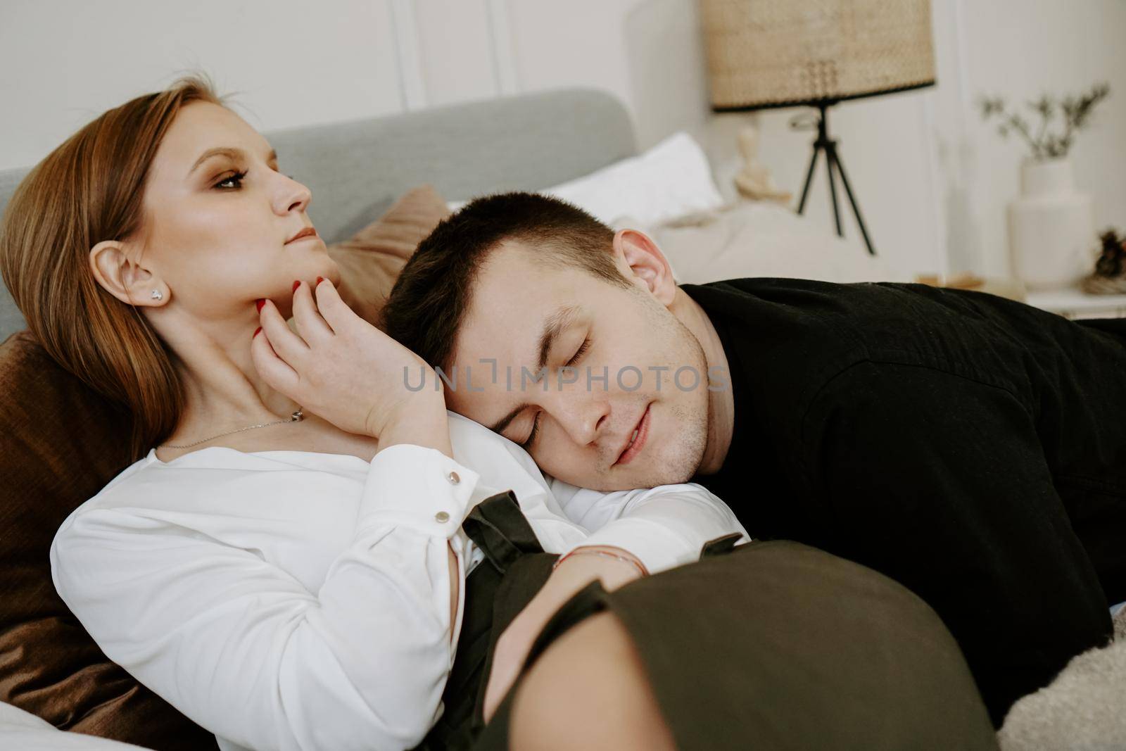 Business couple on bed in hotel room by natali_brill