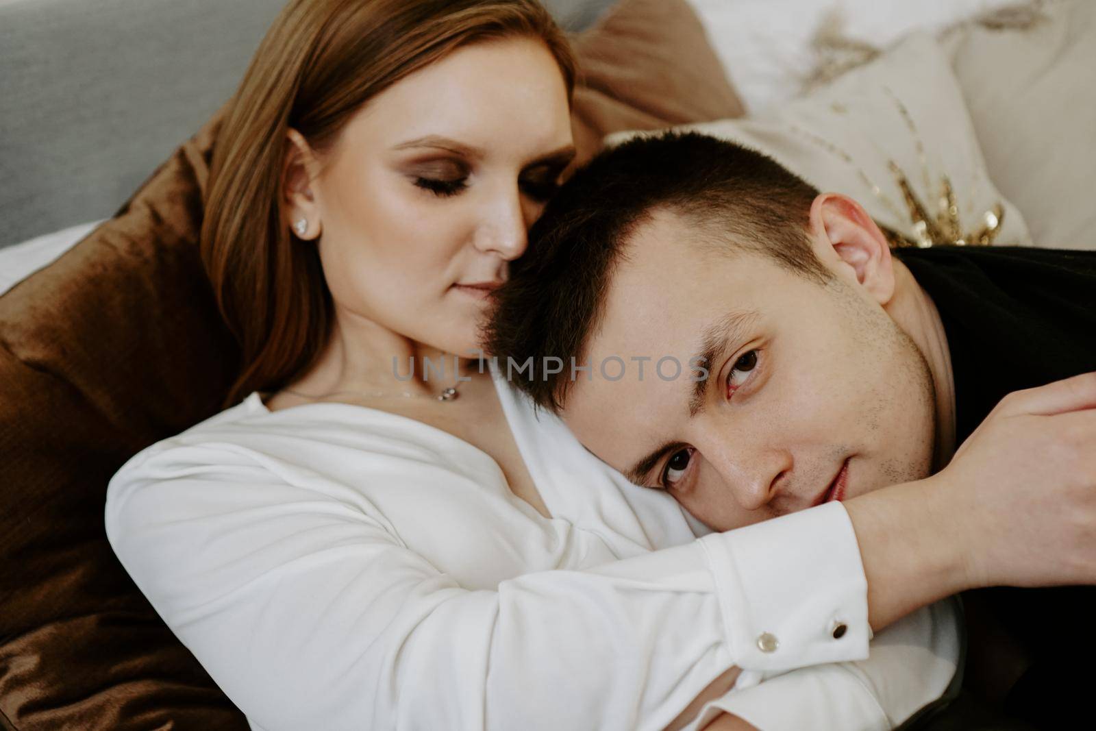 Business couple on bed in hotel room - tender hugs