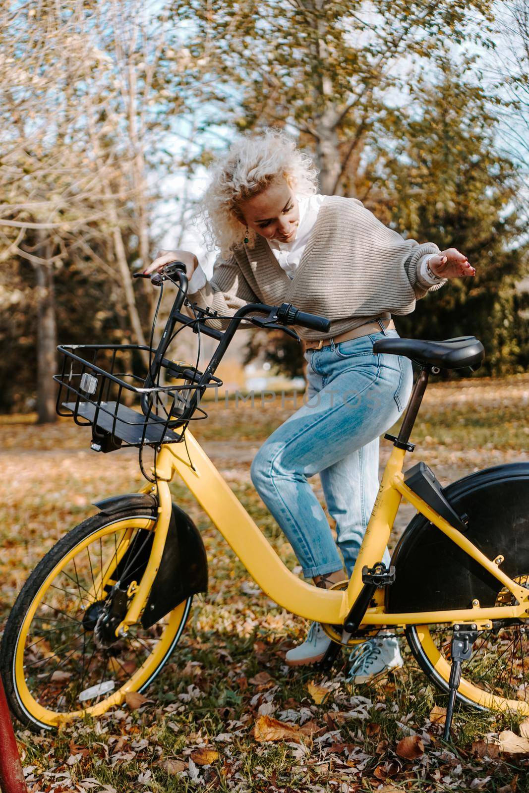 Woman on yellow Bicycle walking in the autumn Park. Middle-aged woman