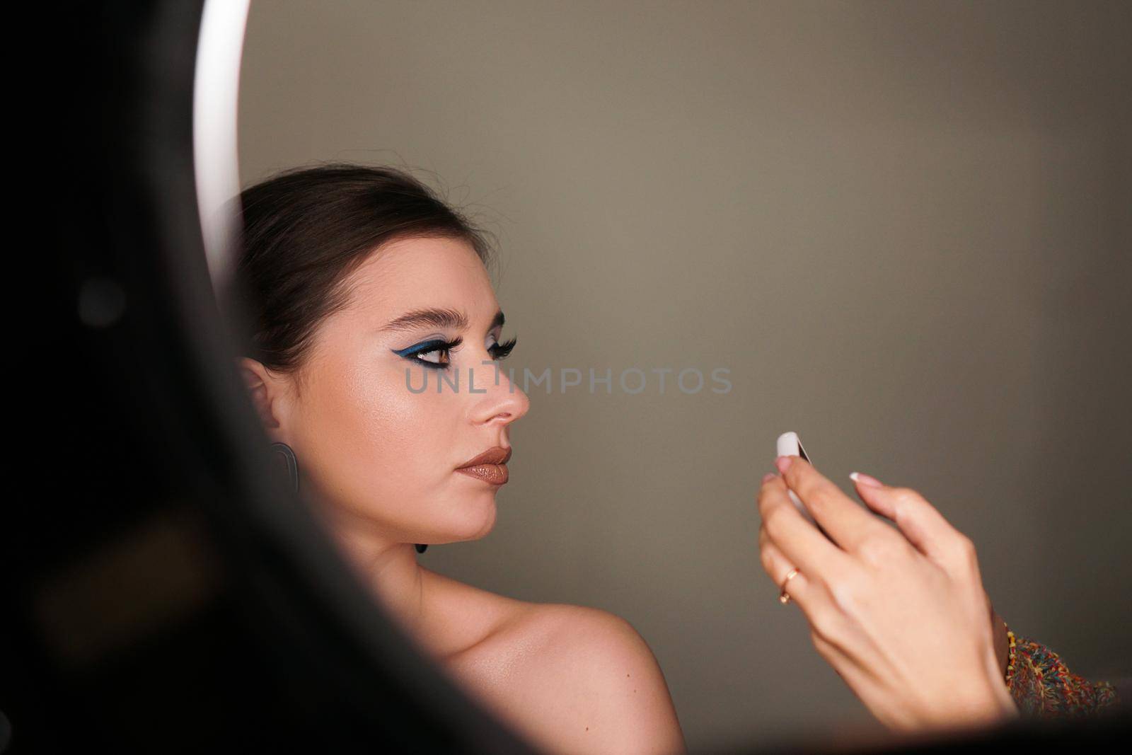 Make up artist taking mobile photo for the model with makeup by natali_brill