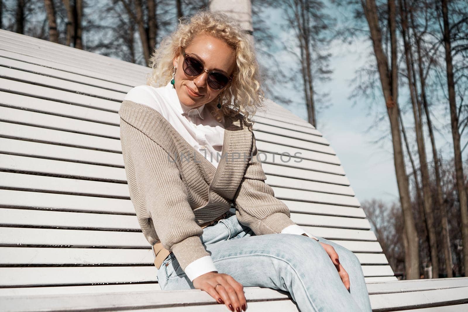 Pretty woman in sunglasses on bench at autumn park alone, lifestyle people concept