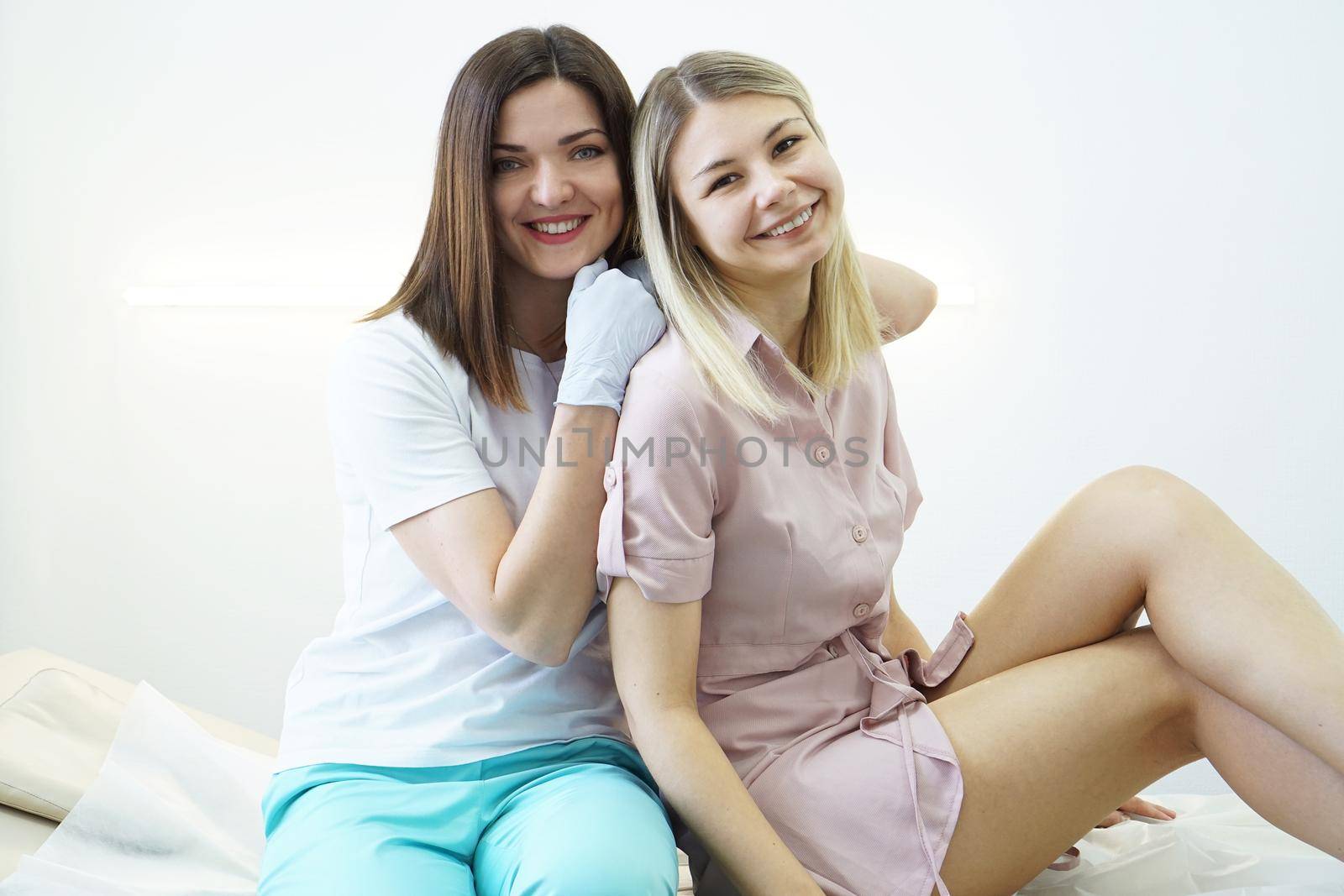 Happy beauty salon master and patient. Body and health care female health concept. Happy patient sitting on a couch and smiling