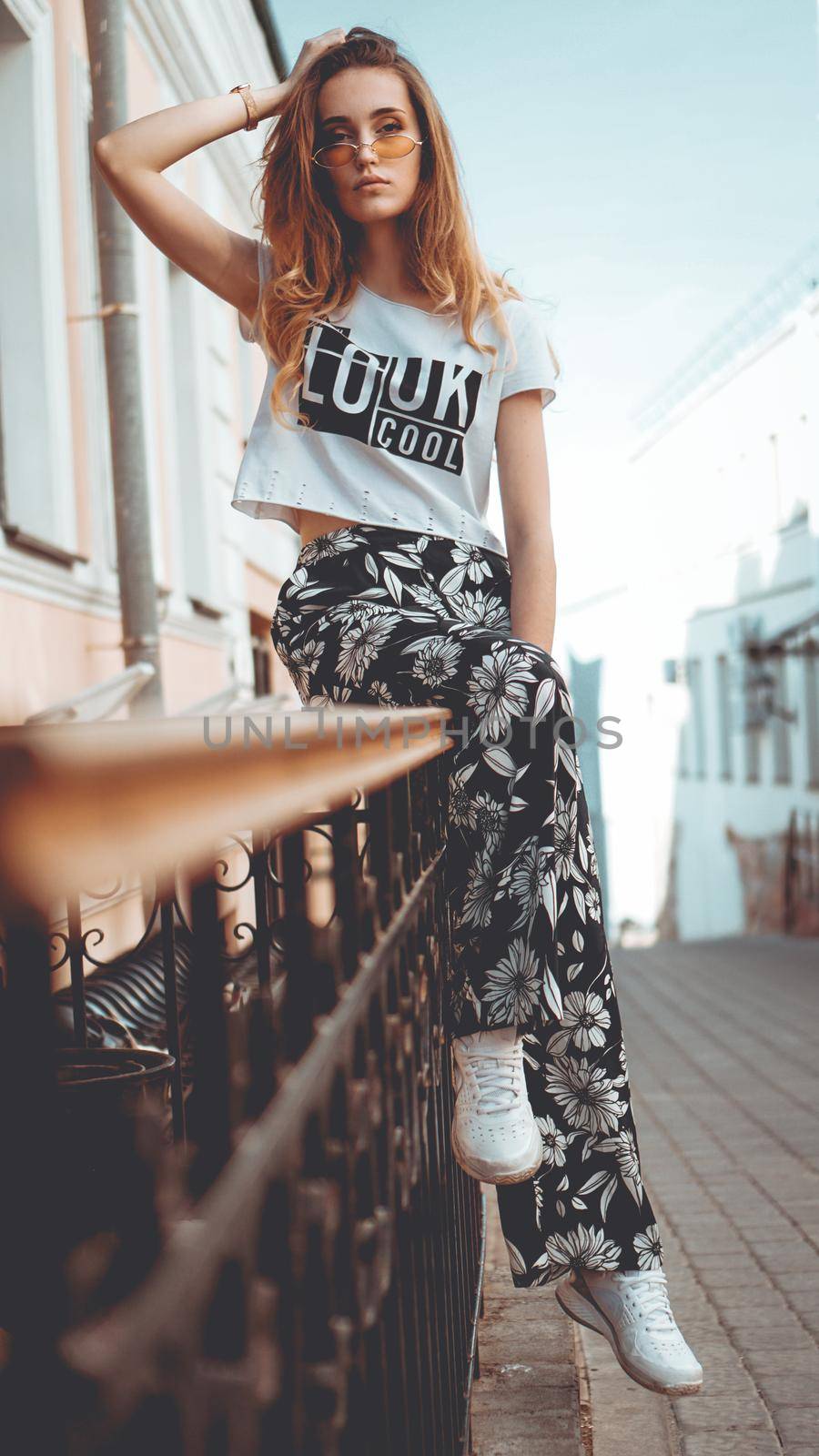 Fashion portrait stylish pretty woman in sunglasses posing in the city, street fashion. You look cool on white t-shirt