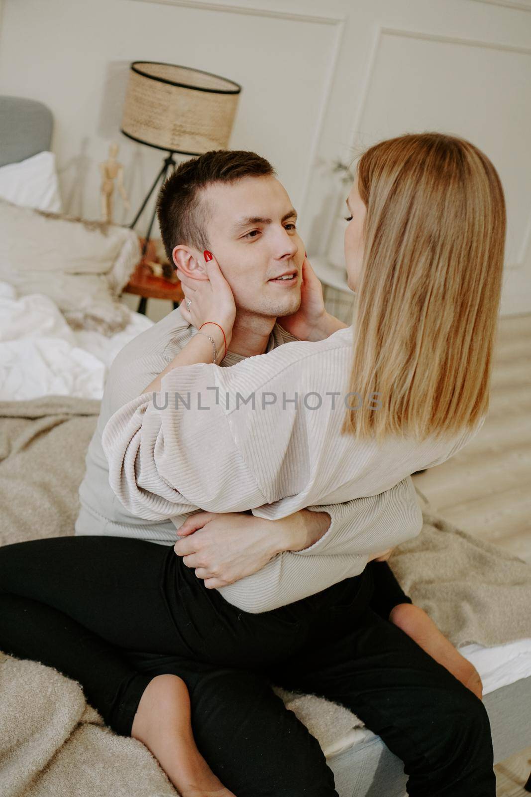 Close-up portrait of a beautiful young couple hugs in bed at home by natali_brill