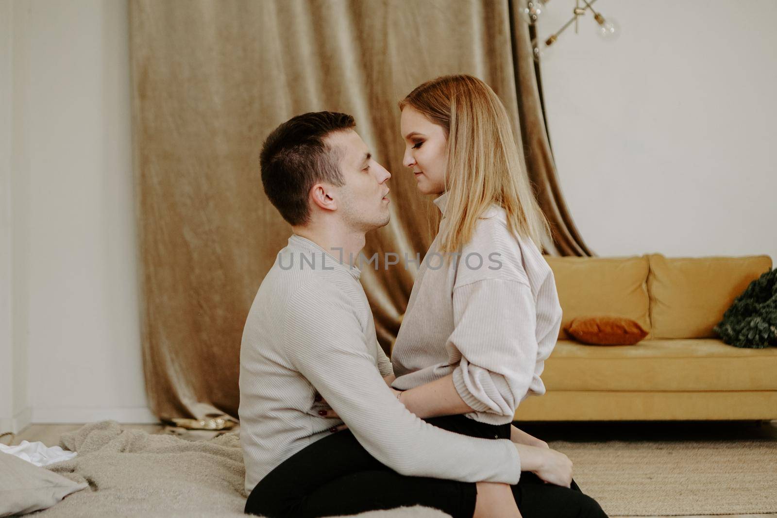 Close-up portrait of a beautiful young couple hugs in bed at home. Soft colors